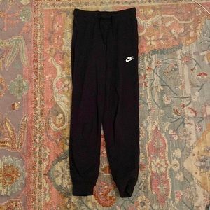 Black women’s Nike sweatpants. Fleece-lined. Cotton, polyester, rayon blend.